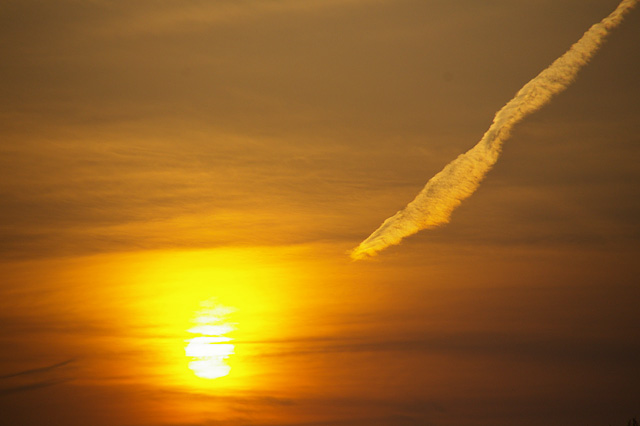 夕日と飛行機雲の写真素材 フリー