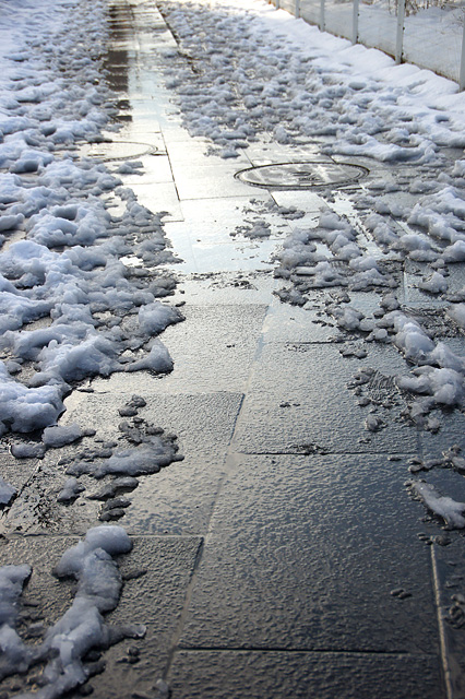 歩道に残った雪と足あとのフリー写真素材