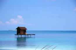 青い海に浮かぶ小屋のフリー写真素材